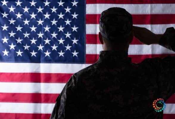 Soldier saluting in front of the flag of the United States