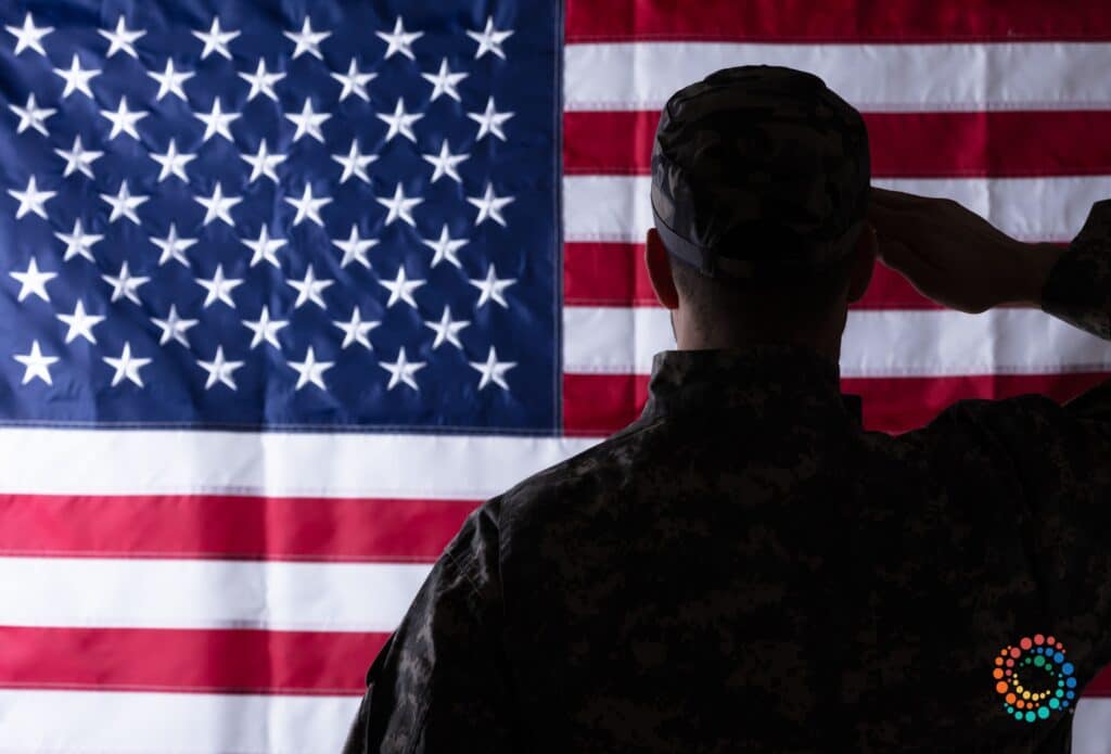 Soldier saluting in front of the flag of the United States