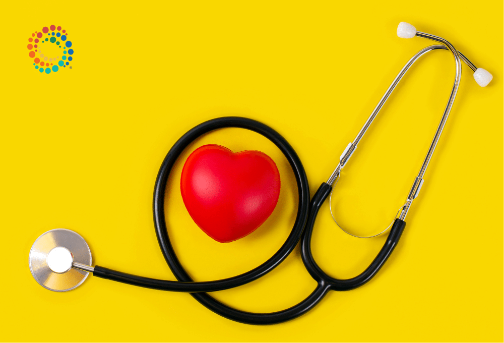 A stethoscope on a bright yellow/gold background with a red heart intertwined in the stethoscope.