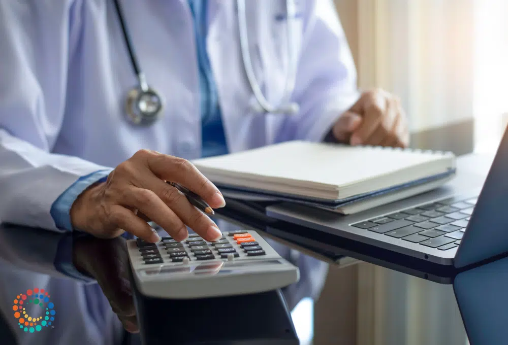 Doctor using calculator at desk